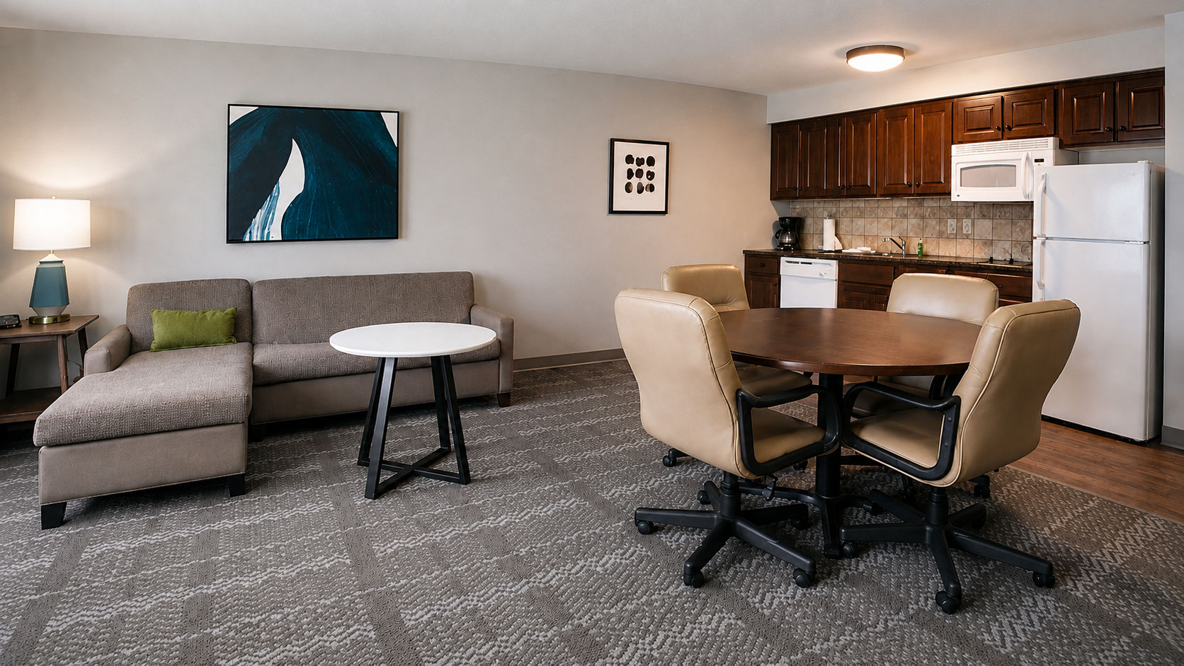 image Open living and kitchen area with sofa and meeting table.