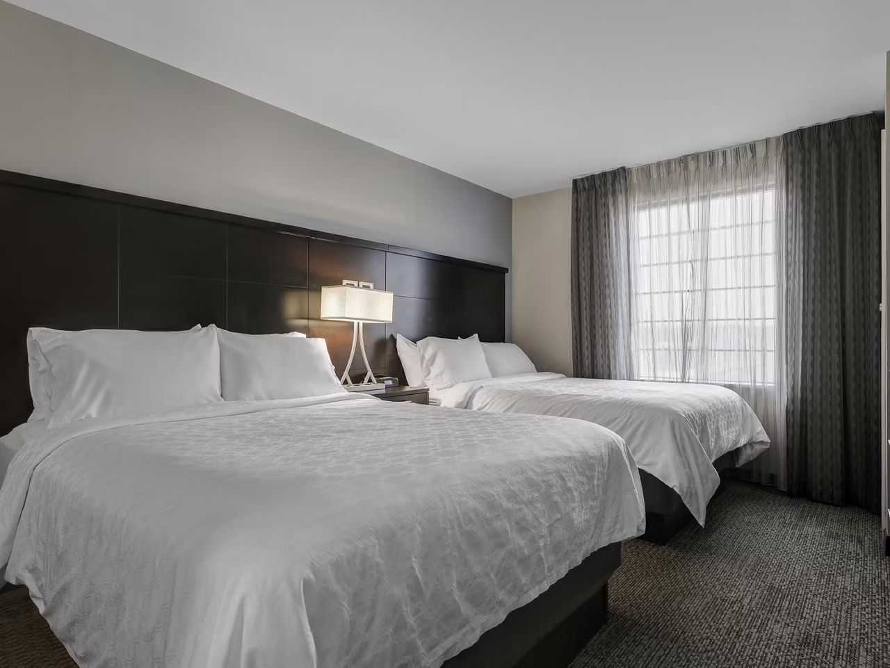 image Relax in a bright bedroom with two queen beds.