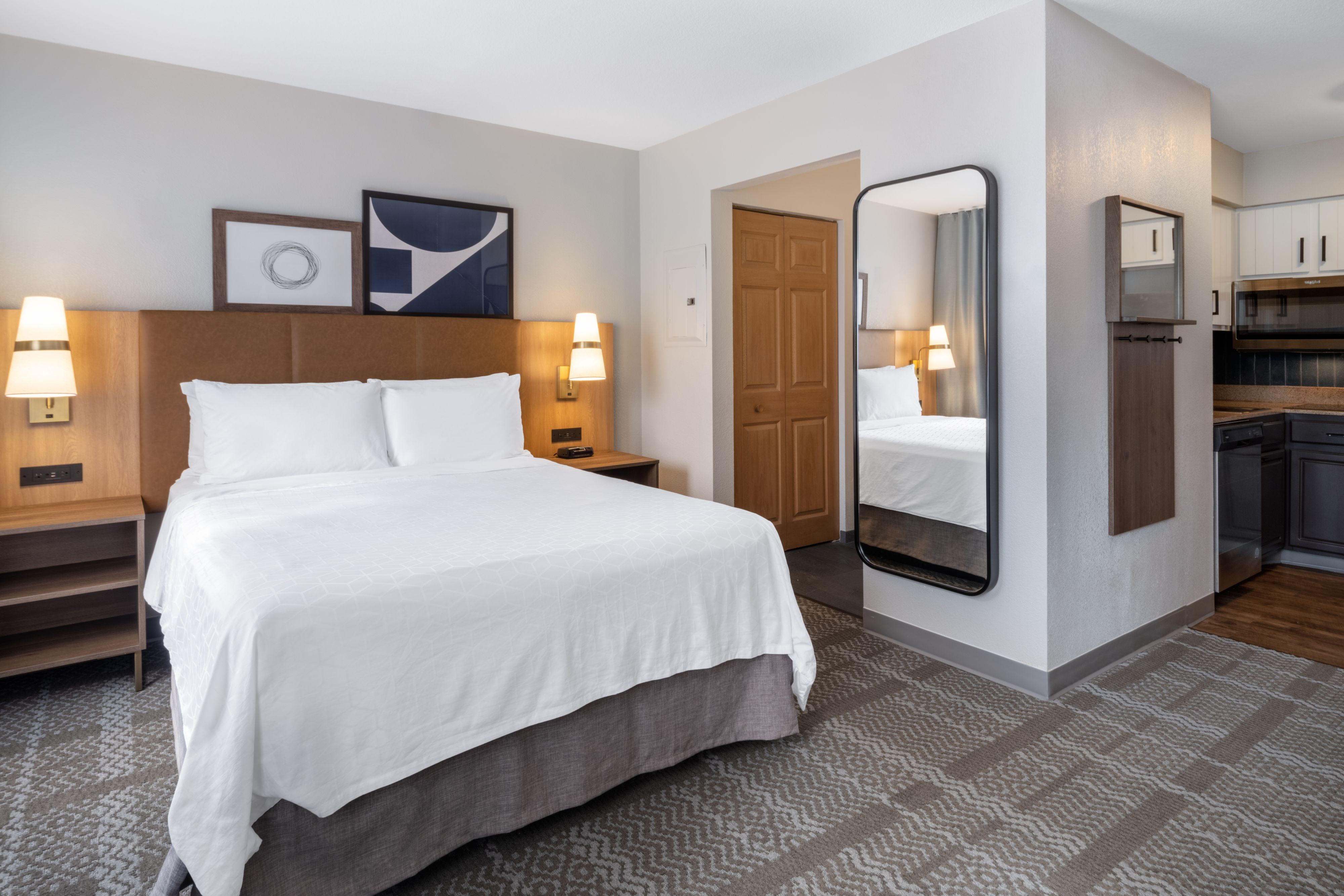 image Bedroom with queen bed, mirror, and bedside lamps.