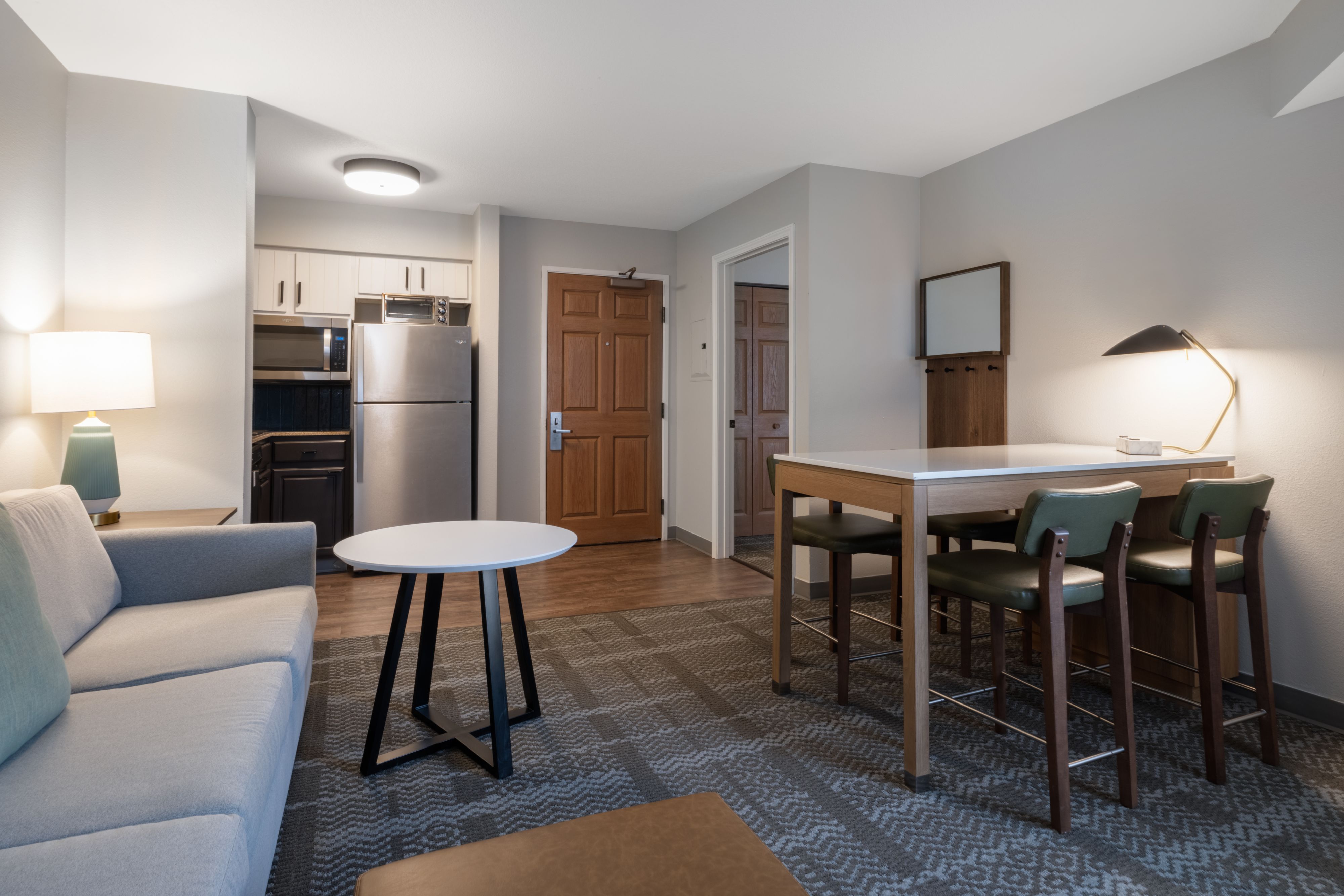image Living area with kitchen, dining table, and sofa.