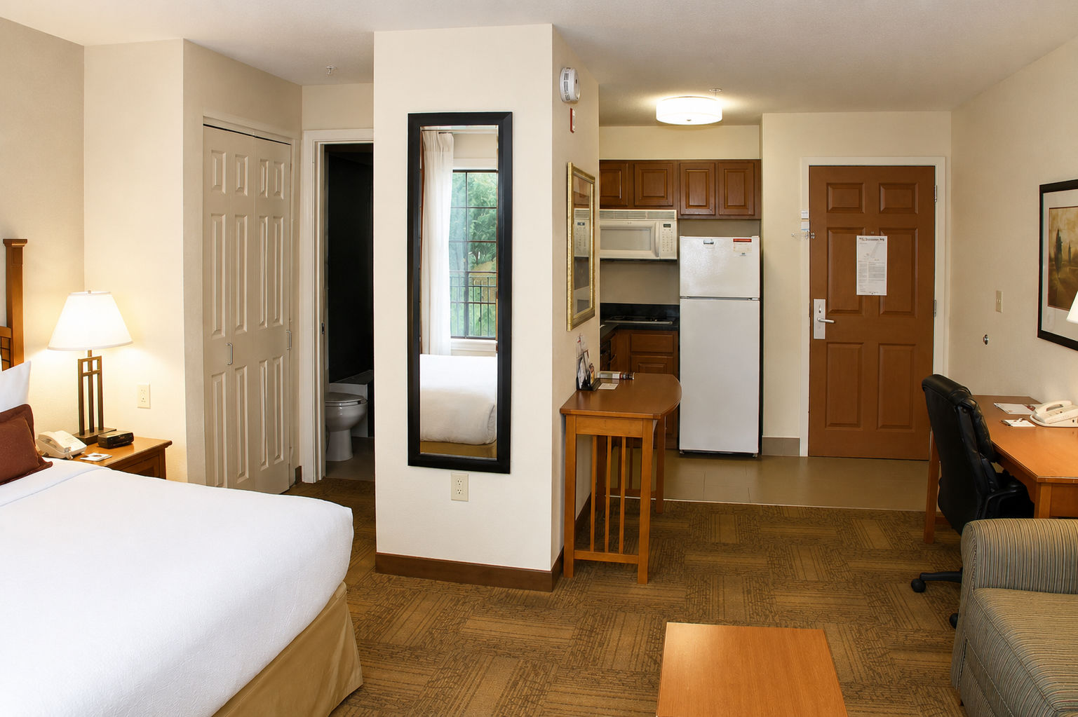 image Studio suite layout with a queen bed, dedicated workspace, and fully equipped kitchen