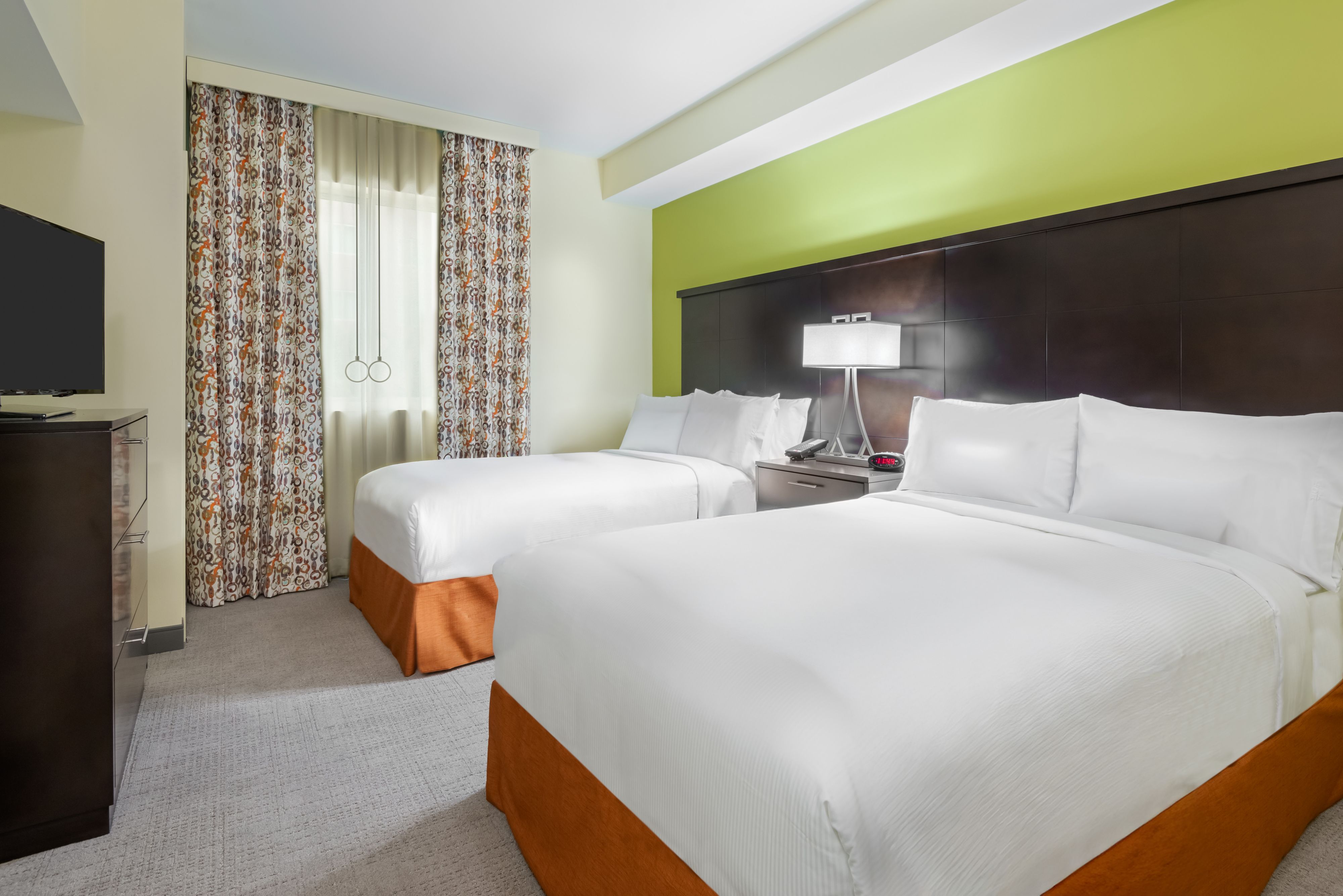 image Enjoy restful nights in this bright suite featuring two queen beds and modern decor.
