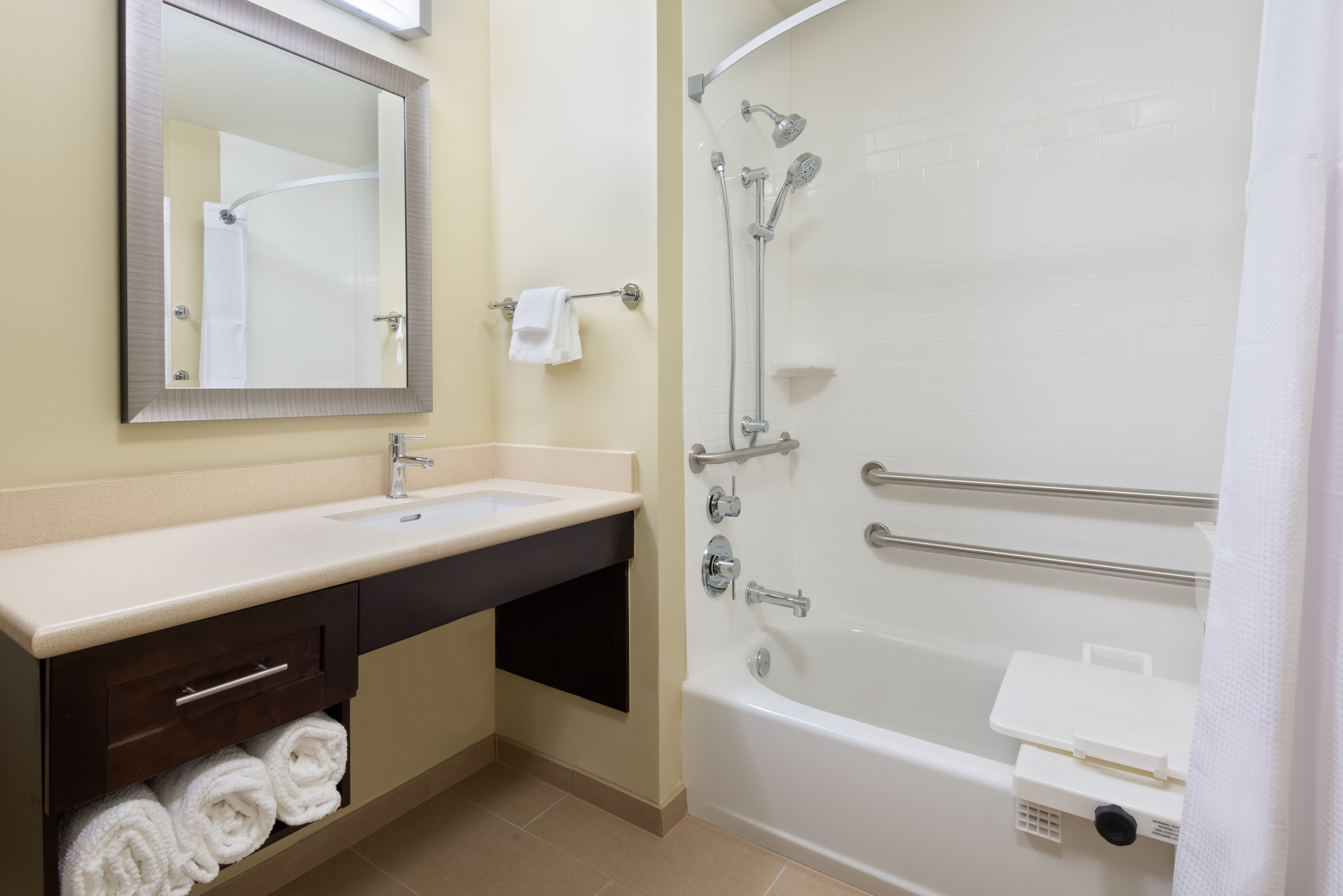 image Experience comfort in the accessible bathroom, equipped with convenient grab bars and a relaxing tub.