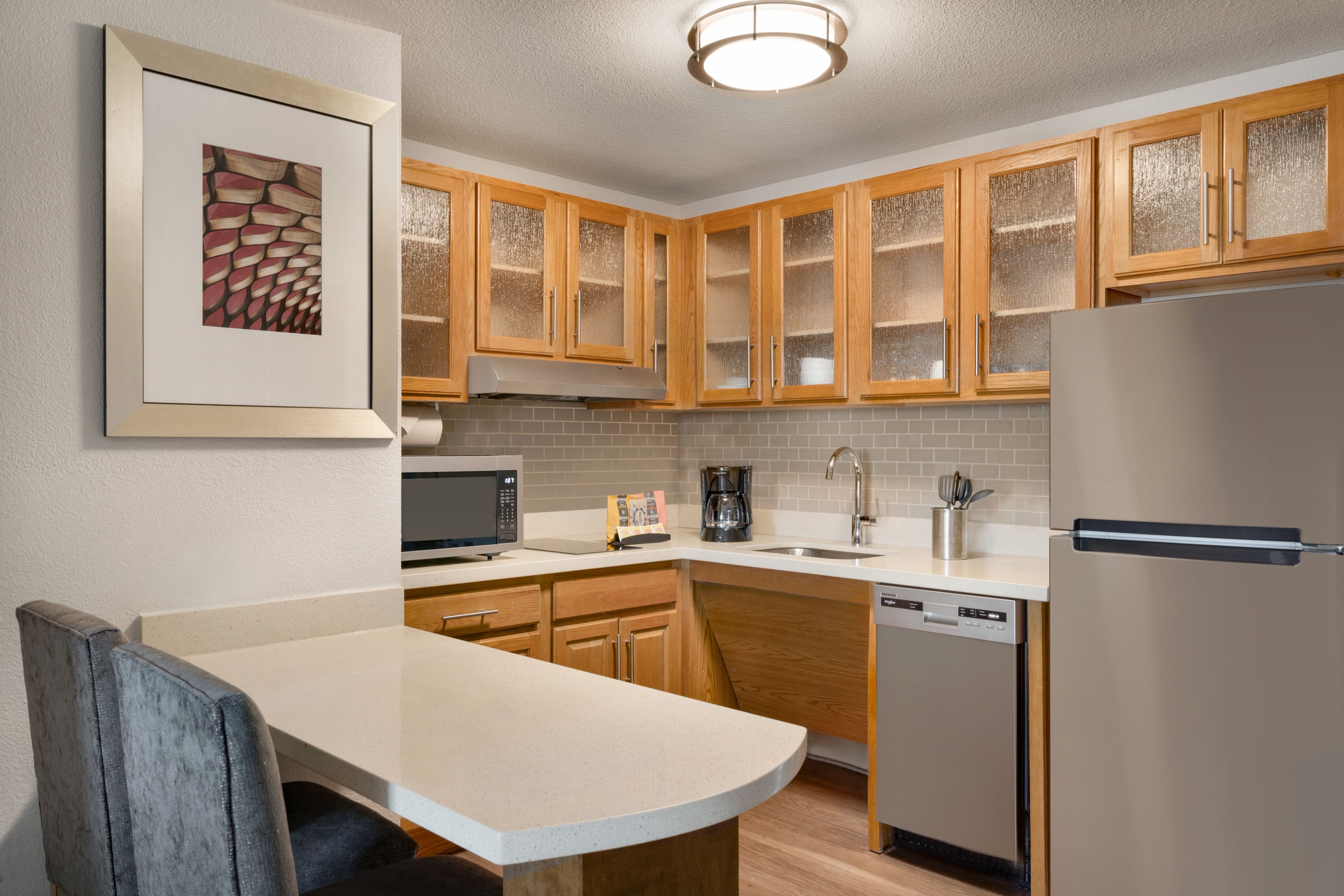 image Compact kitchen with modern appliances and cabinetry.