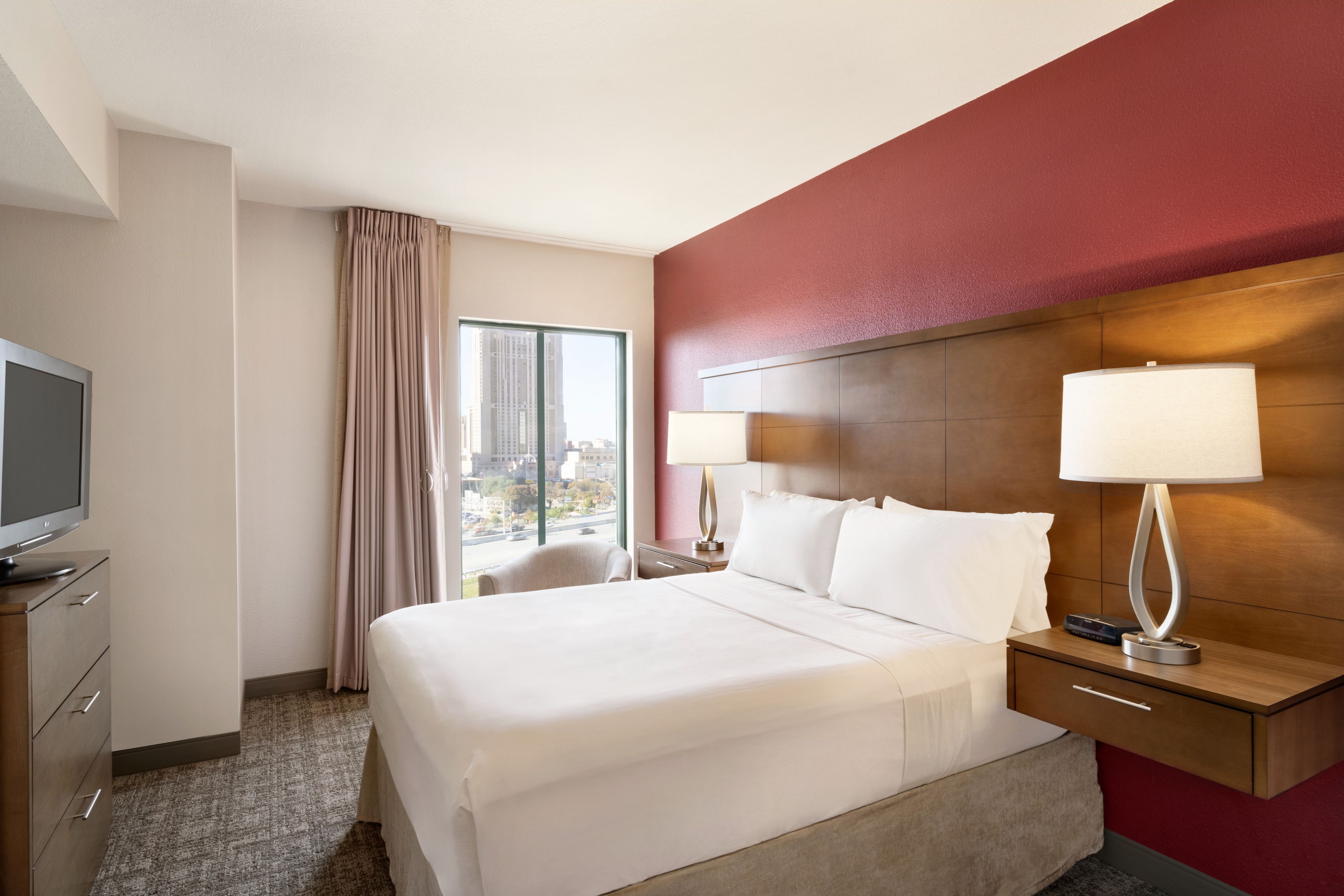 image Cozy queen bed with soft pillows and nightstand lamps.