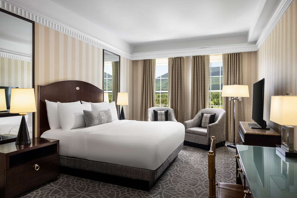 image Wake up to mountain views from your cozy king room adorned with elegant decor and soft lighting.