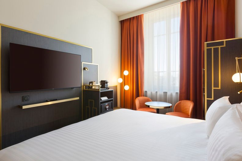 image The classic room's well-appointed workspace and seating area, with a flat-screen TV and warm ambient lighting for a relaxed stay.