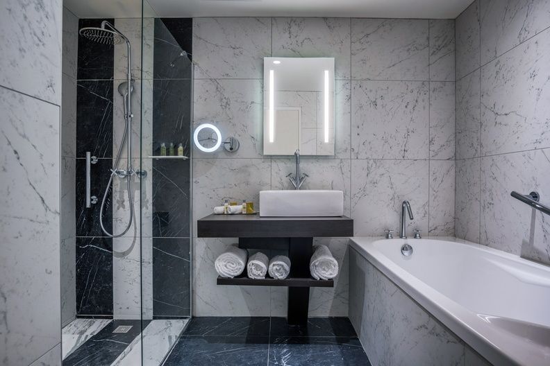 image Grey marble bathroom with a freestanding soaker tub and separate walk-in shower.