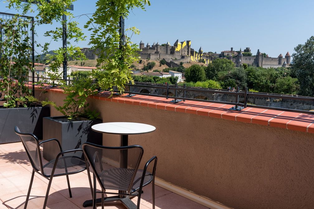 image Private terrace with table and chairs overlooking the Cité Médiévale — included with Deluxe rooms.