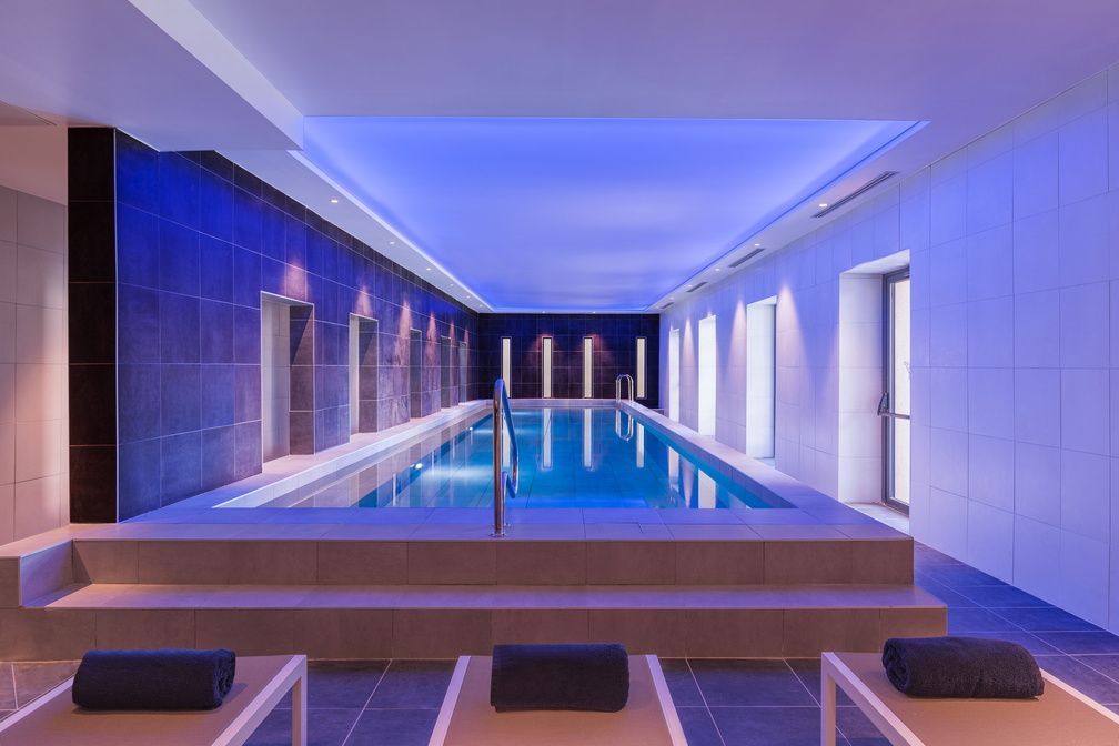 image The 35m² indoor pool lit in deep blue — free access daily from 10am to 10pm.