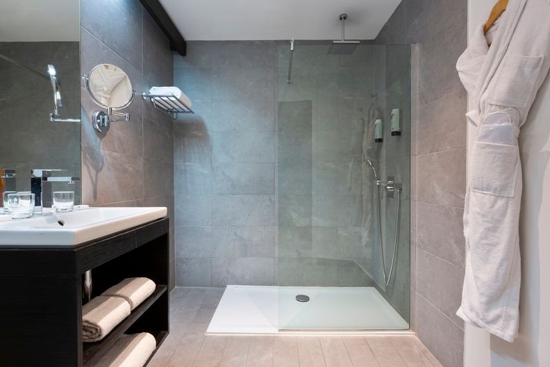 image The modern en-suite bathroom features a spacious walk-in shower and clean-lined finishes, complementing the contemporary style of this wing of the property.
