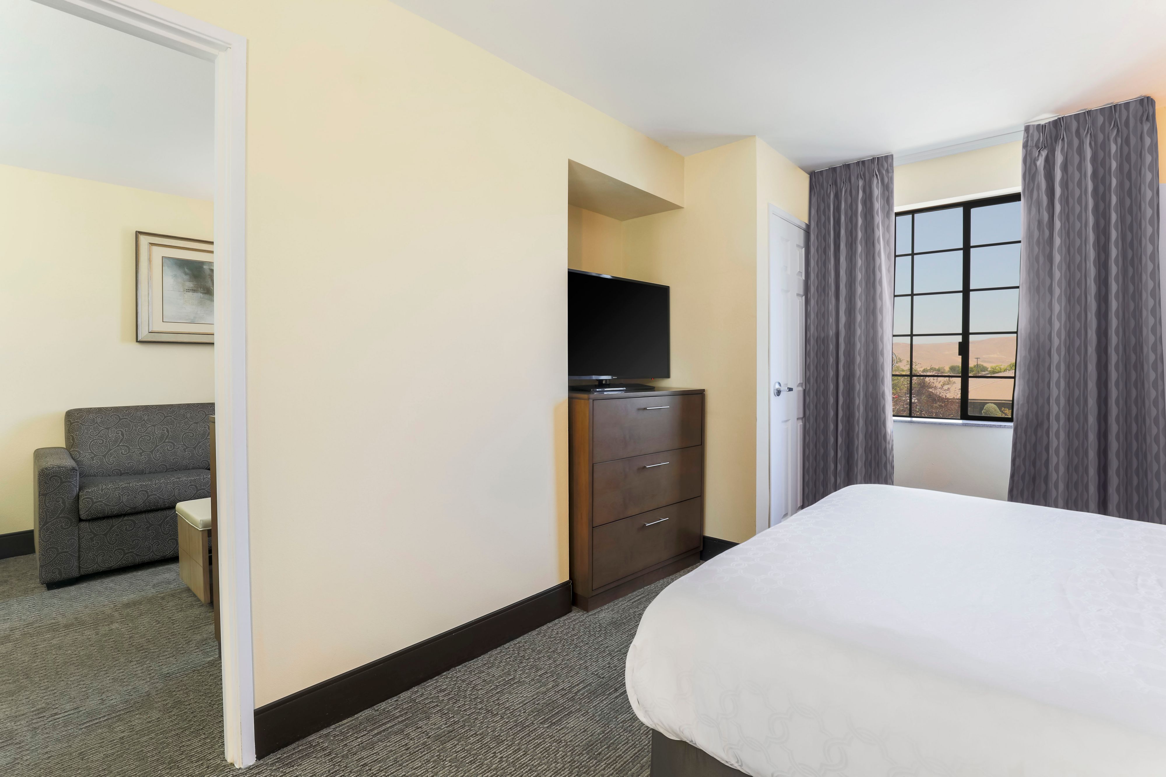 image Settle in to the bedroom's cozy bed, flat-screen TV, and couch in the living room.