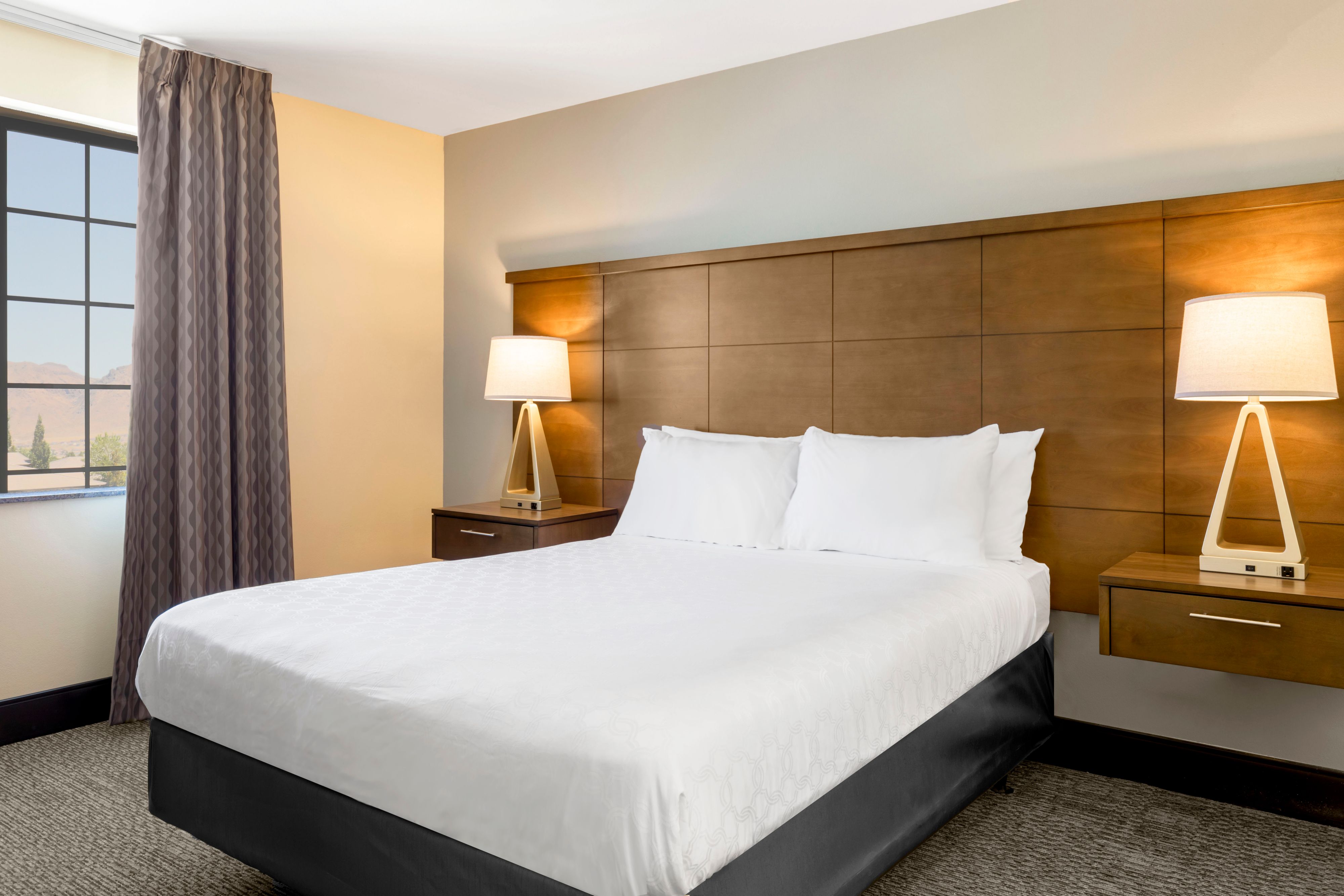 image Rest easy in the bedroom's queen bed, warmly lit by bedside lamps.