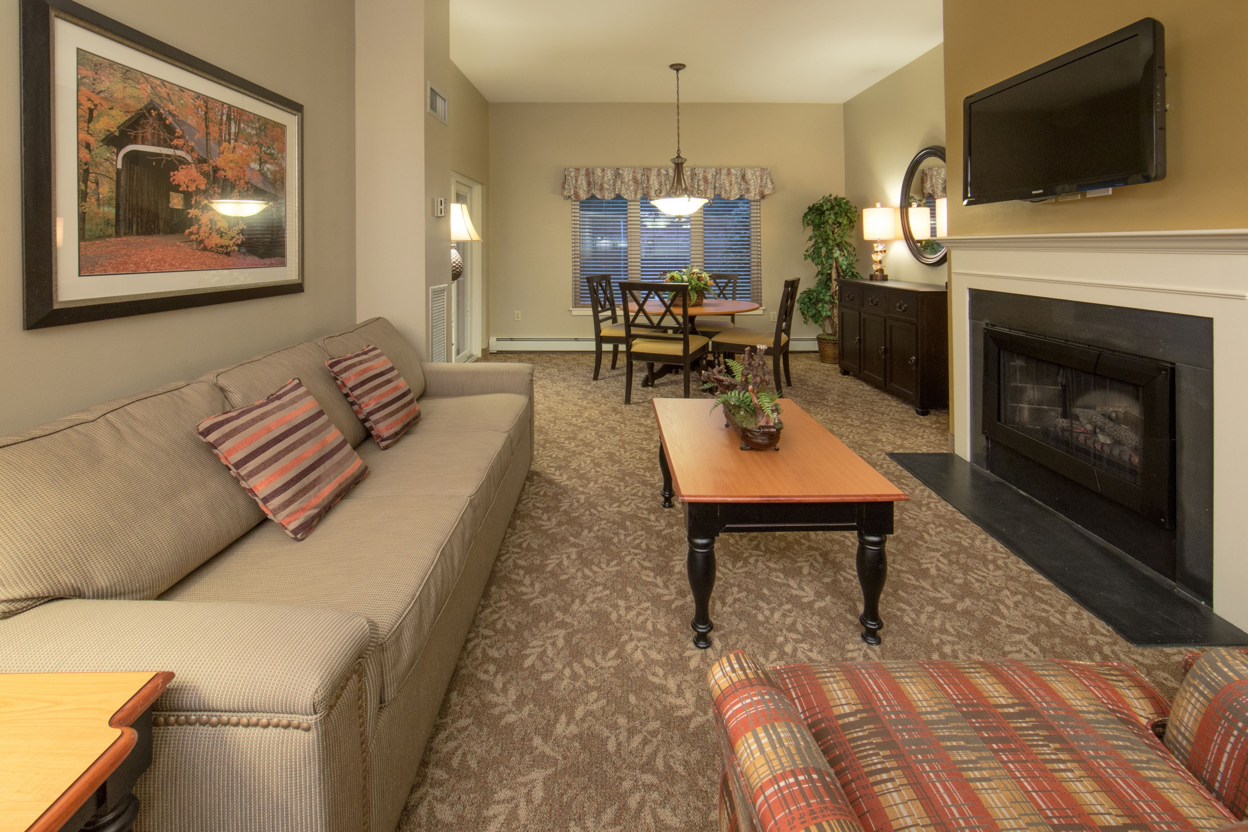 image Living area with sofa, dining table, and fireplace.