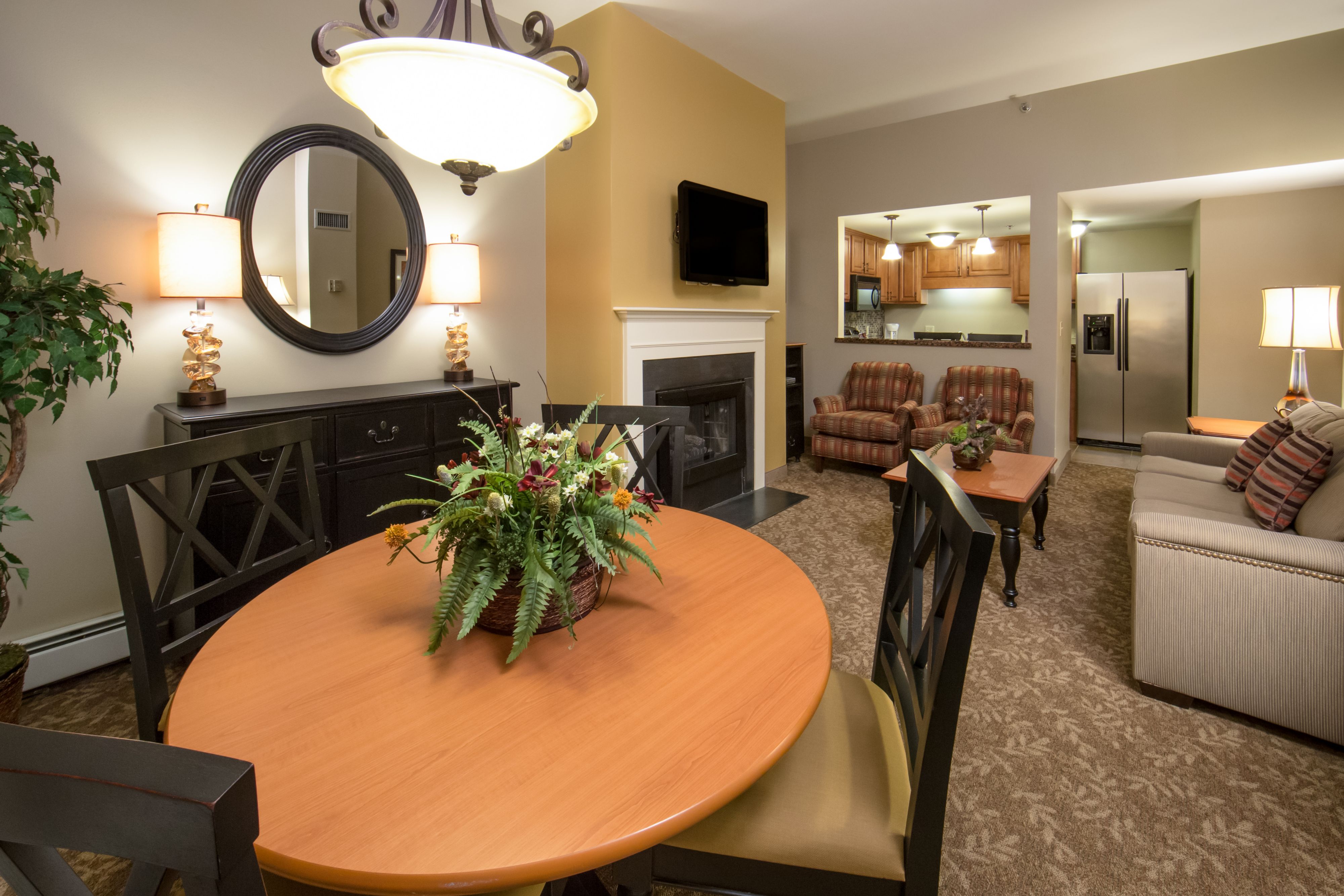 image Dining area with table, seating, plants, and fireplace.