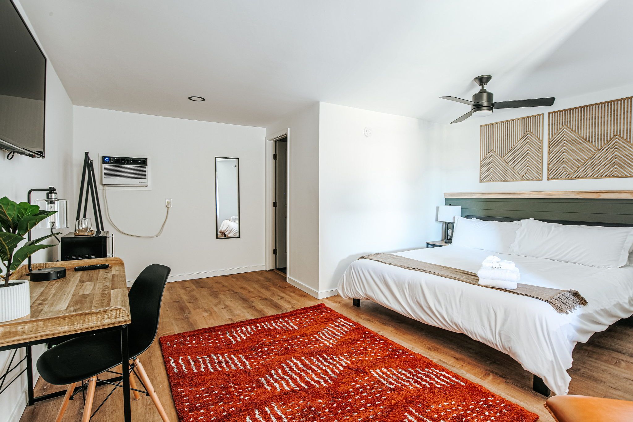 image Relax in a cozy space featuring a king bed, a beautiful accent rug, and a desk for your adventures.