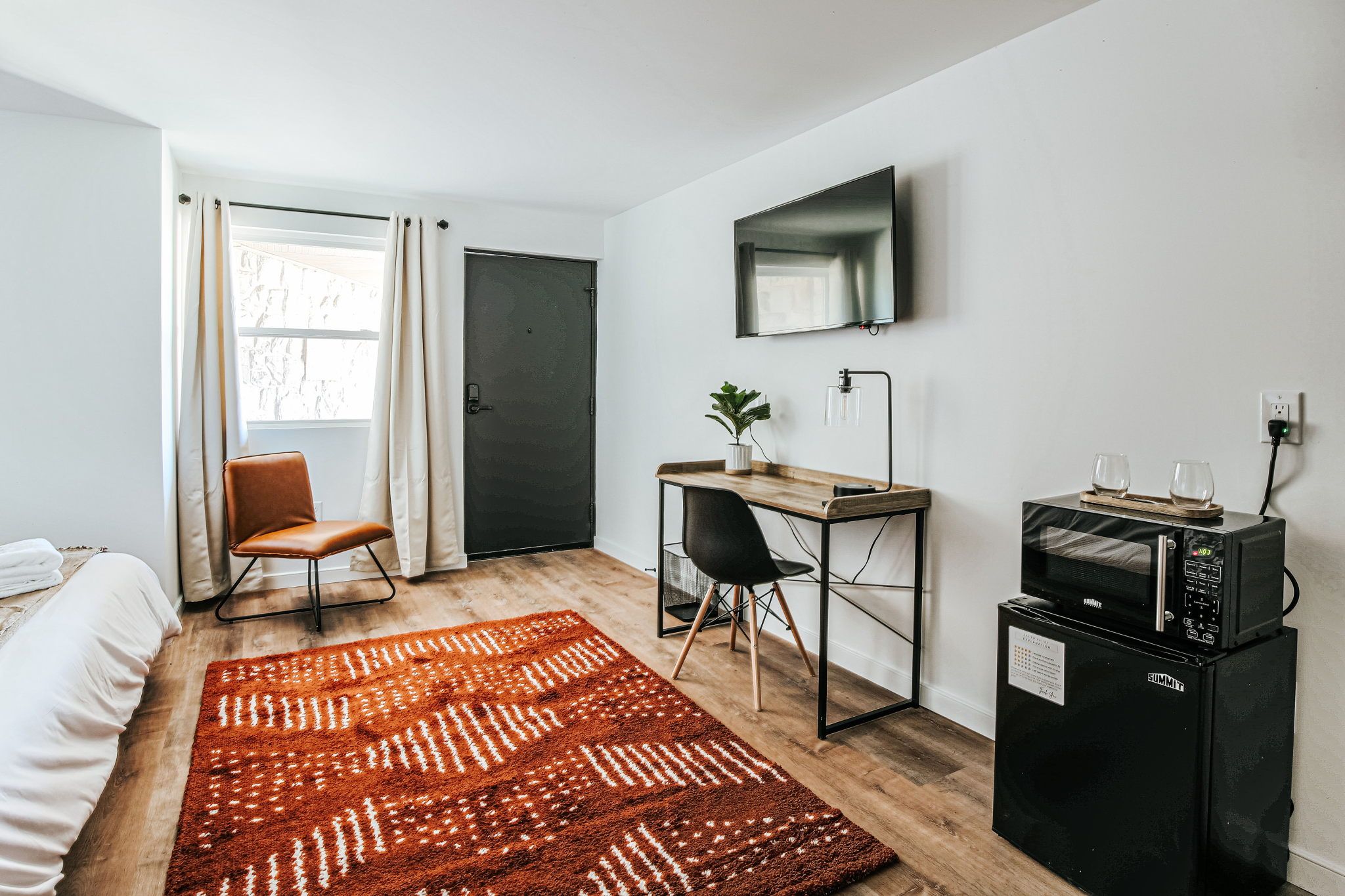 image Sit back in this chic space with a sleek workspace, soft chair, and mini fridge just a step away.