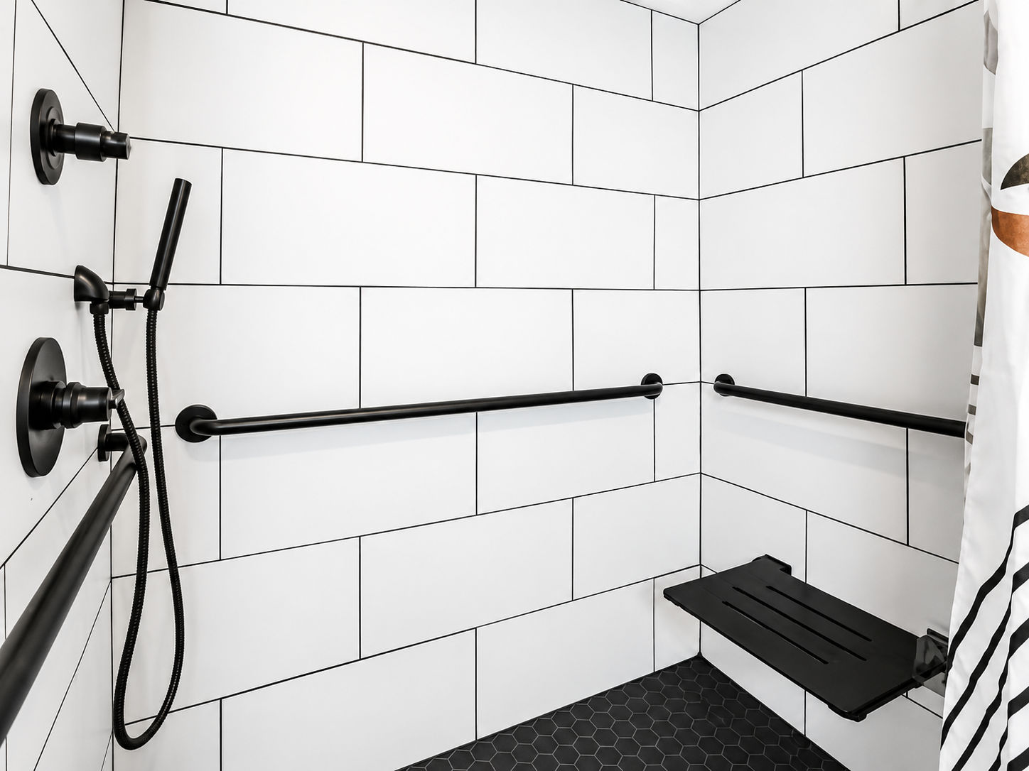 image Roll-in shower with grab bars — the bathroom is fully accessible with step-free entry throughout the room.