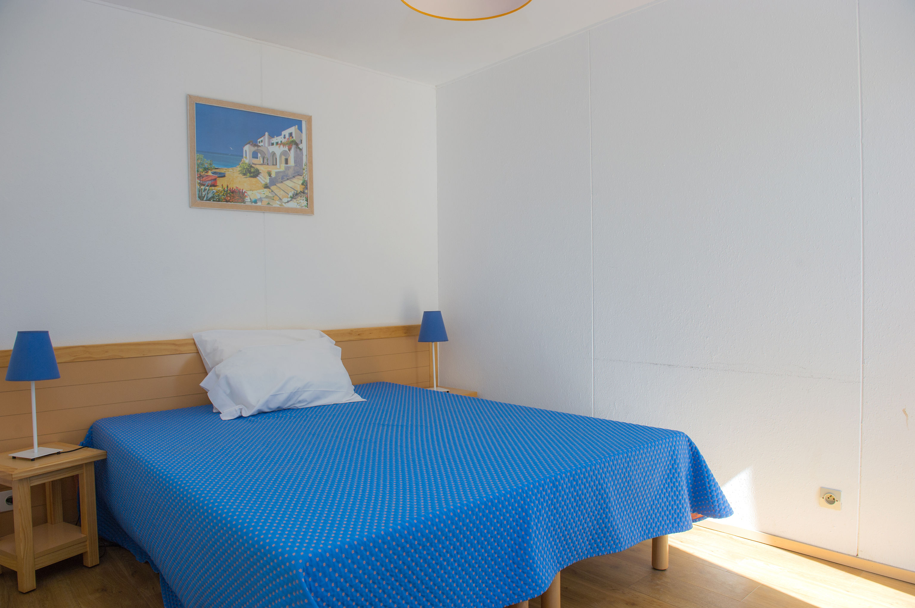 image The double bedroom, bright and airy with warm wooden beams and Mediterranean blue tones.
