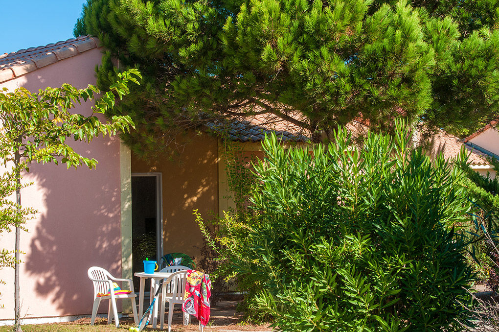 image A shaded terrace surrounded by Mediterranean greenery, the perfect spot to relax outside your villa.