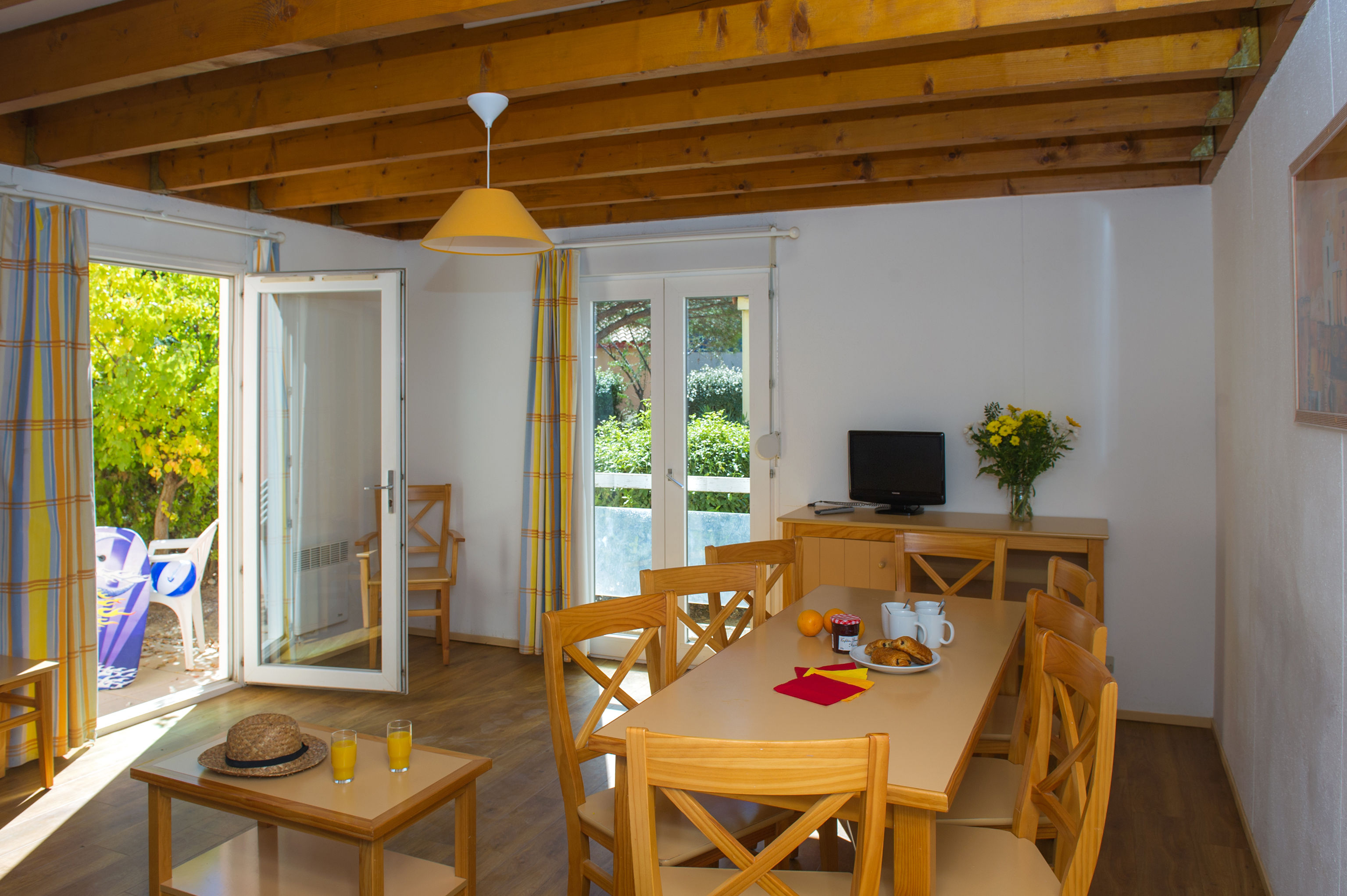 image The bright dining area with warm wooden beams and direct access to the private terrace.