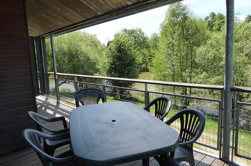 image Terrace with a table and chairs looking out over the treetops and the lake.