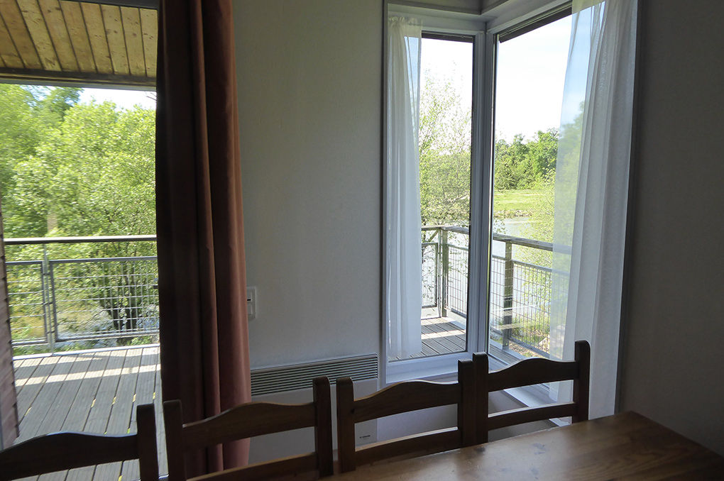 image Dining area with sheer curtains and a wide opening onto the covered terrace.