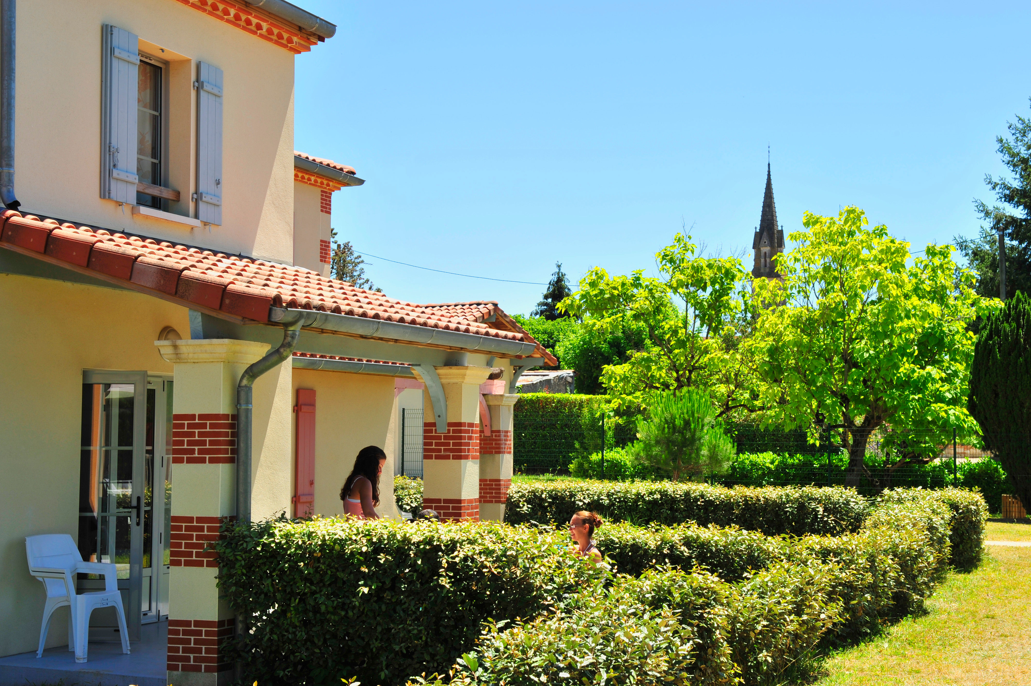 image Ground-floor terrace with a private garden view — Nérac's church spire rises above the trees just beyond the hedge.