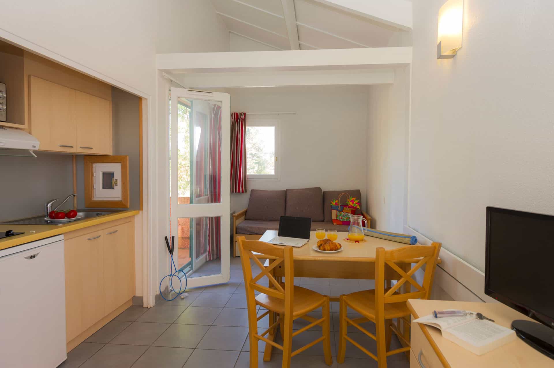 image Another view of the living and kitchenette area, with garden furniture visible through the glass terrace doors.