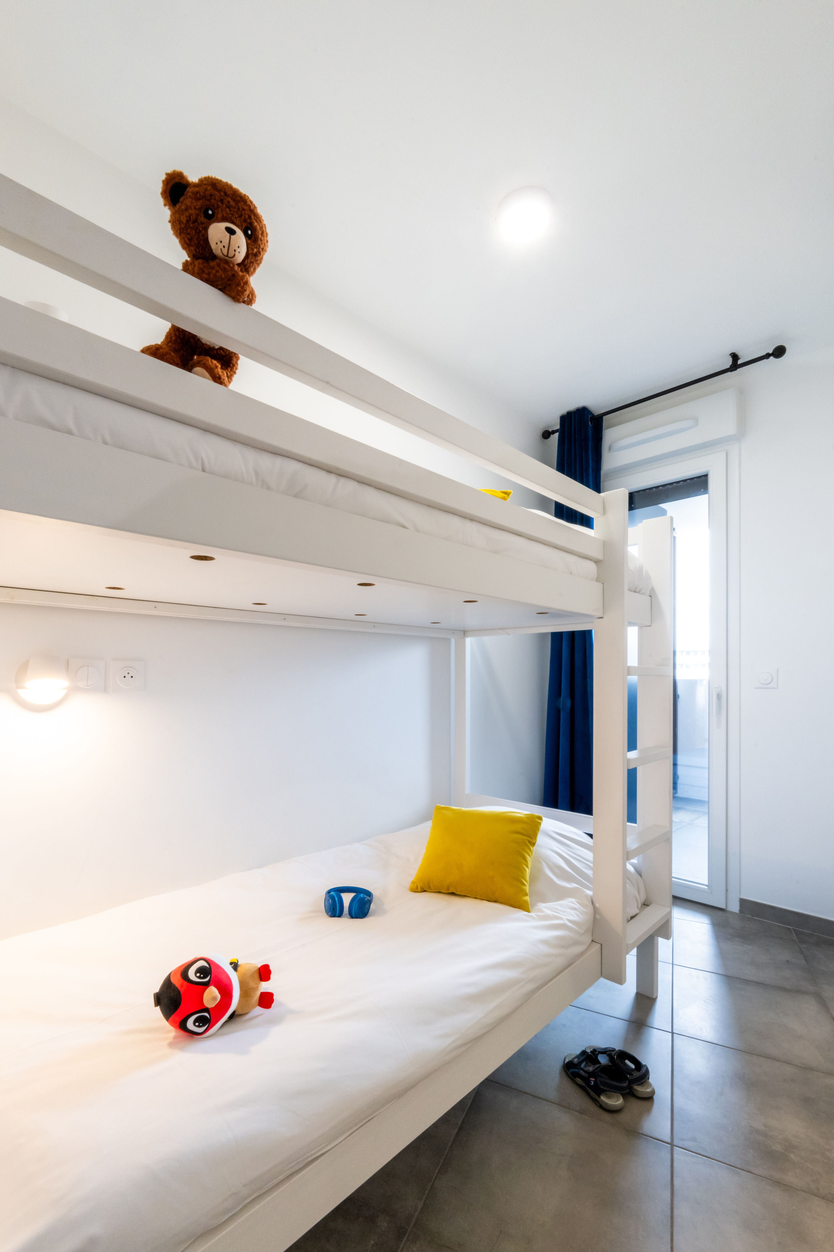 image White bunk beds with colourful cushions in the cabin area — a dedicated sleeping nook designed with kids in mind.