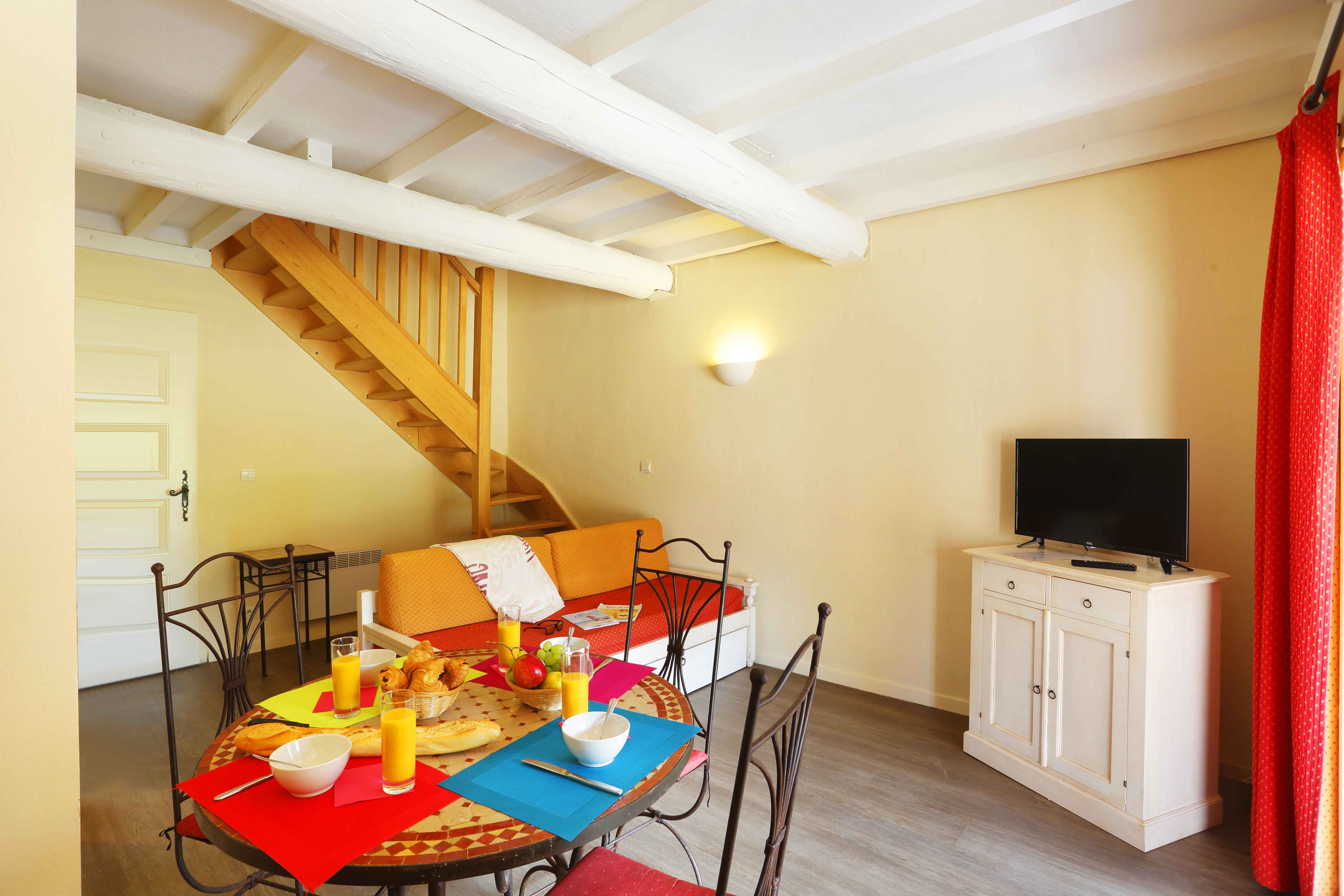 image With a double sofa bed and TV, the generous living area comfortably accommodates the full group across two levels of this 56 m2 duplex.