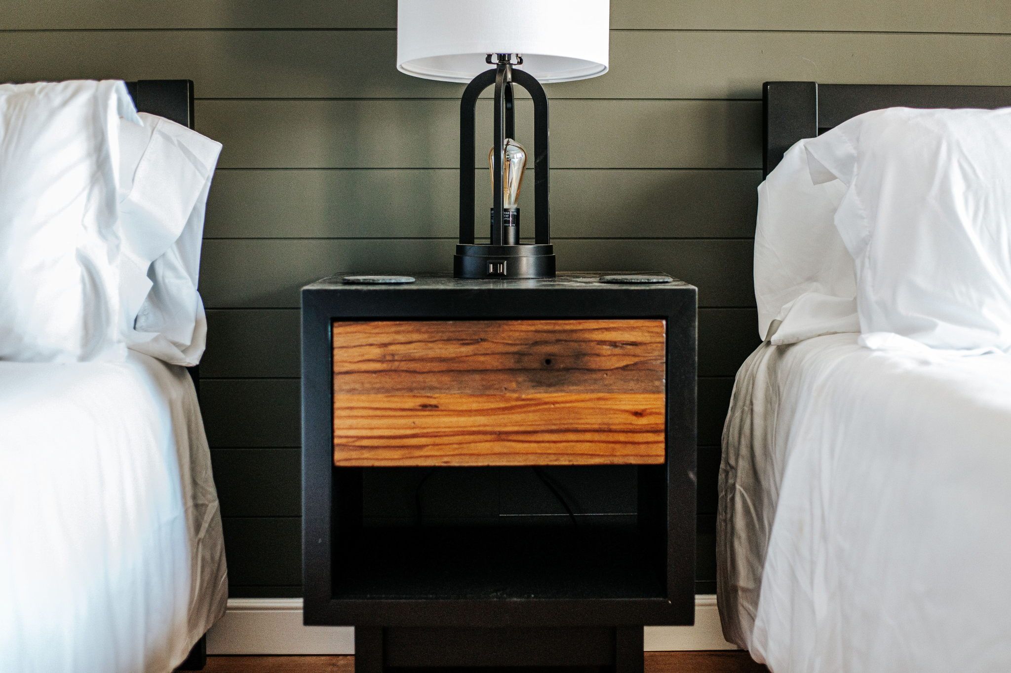 image Simple sophistication meets functionality with a stylish nightstand and unique lamp to brighten your stay.
