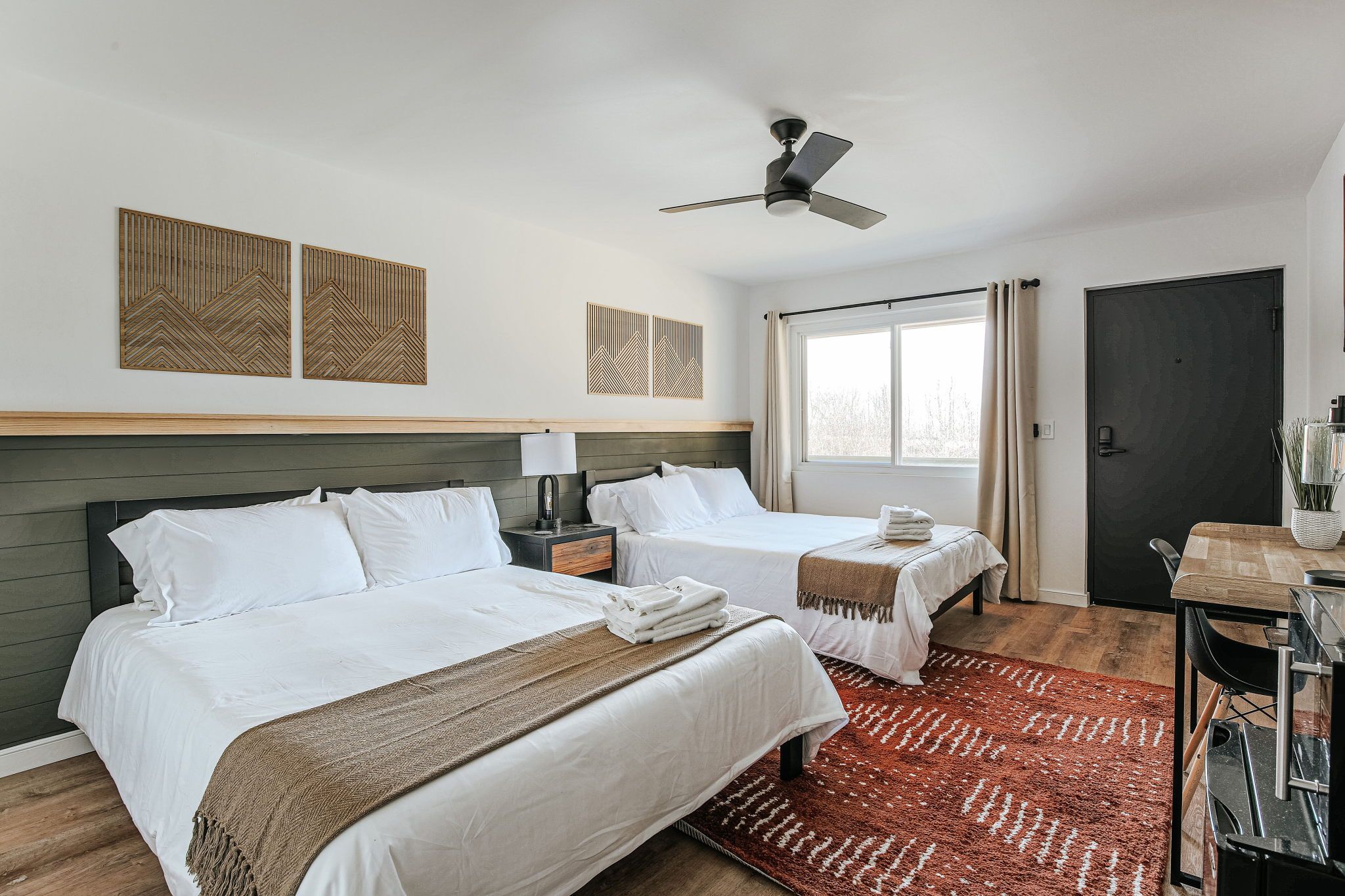 image Unwind with modern comfort in this spacious room with two queen beds, perfect for group adventures.