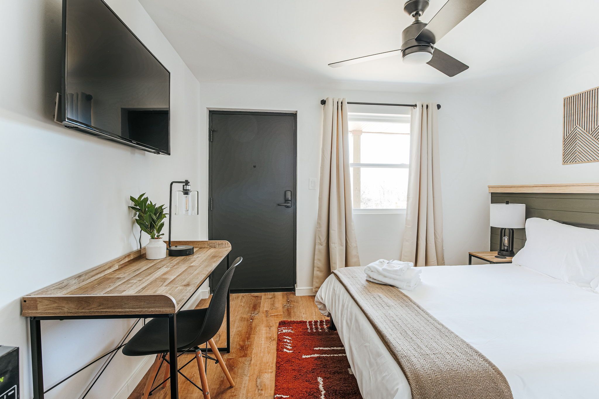 image Relax in a stylish suite featuring a cozy queen bed, sleek furnishings, and a smart TV for entertainment.