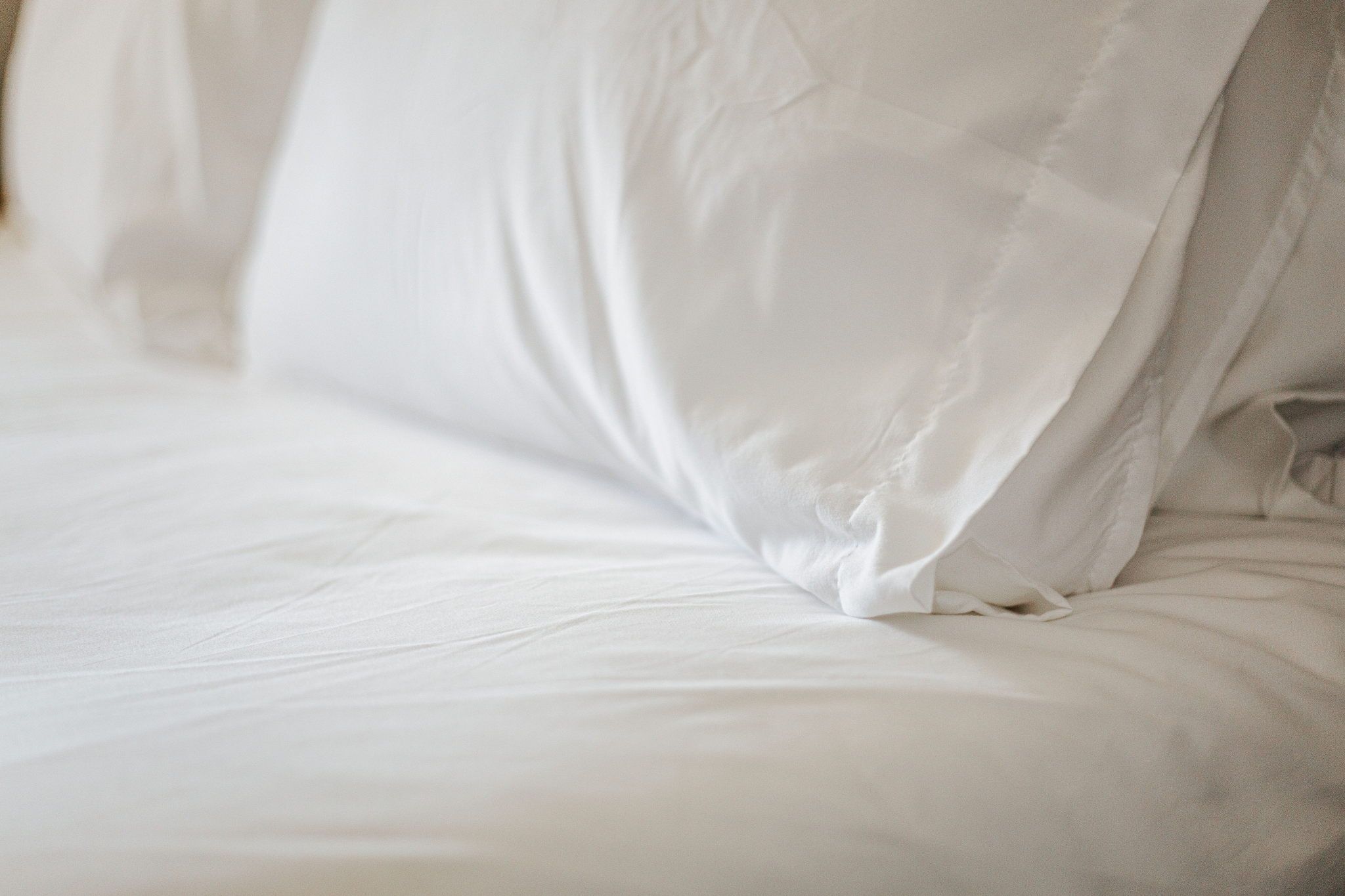 image Plush white pillows and linens invite you to relax and unwind in comfort.
