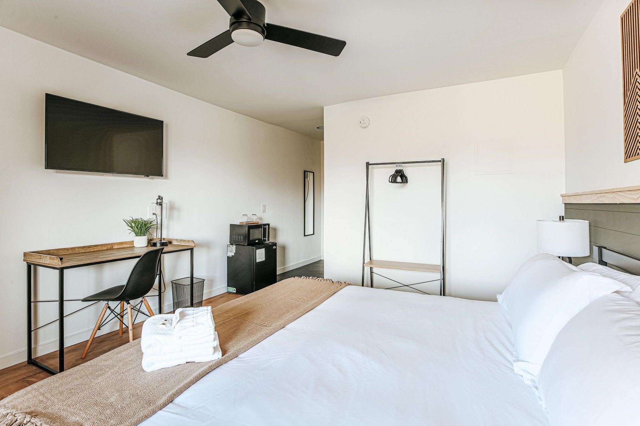 image Embrace comfort with a cozy king bed, modern decor, and a dedicated workspace designed for relaxation.
