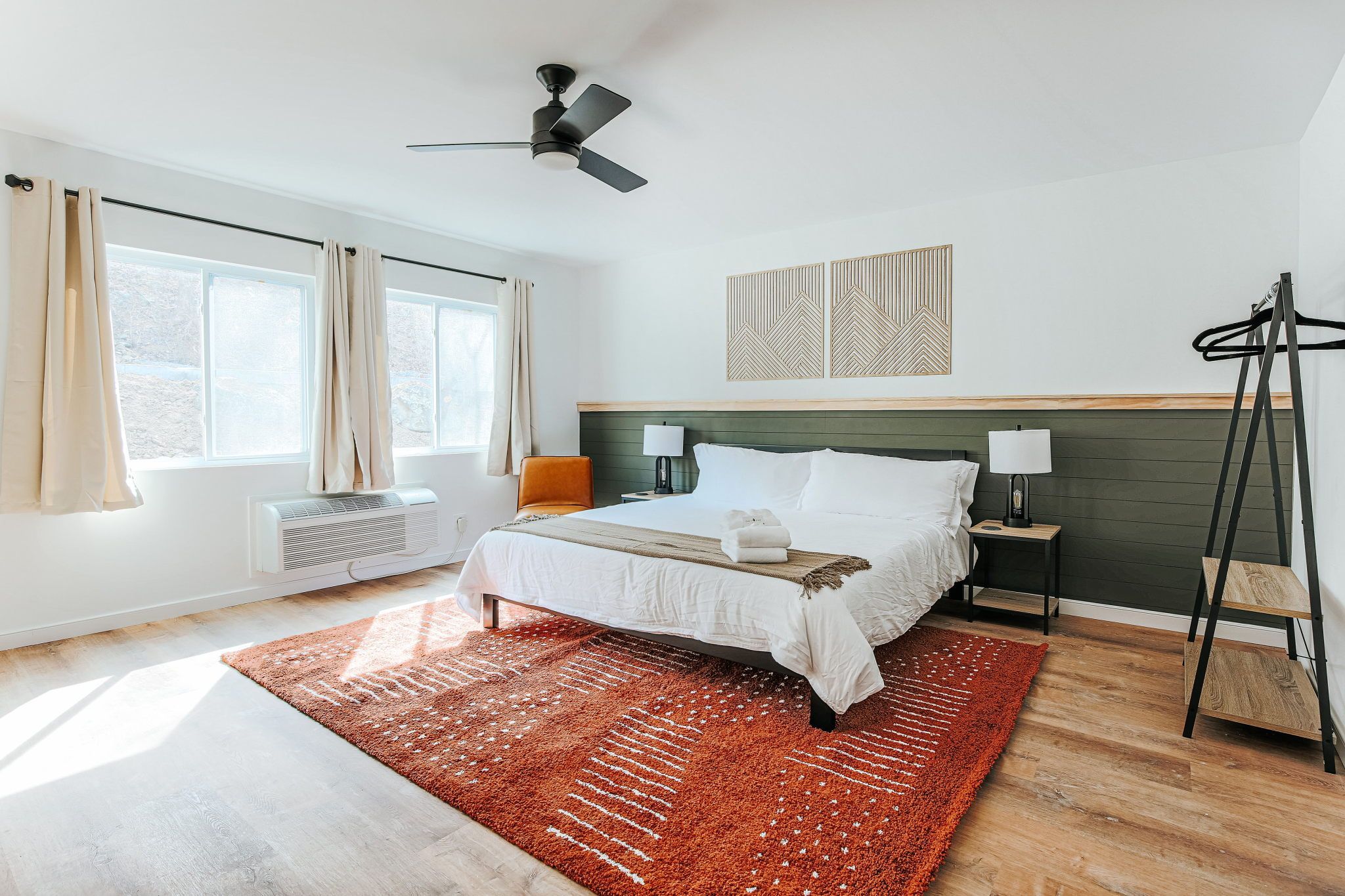 image Wake up in a bright, airy room featuring a plush king bed and cozy seating for your morning coffee.