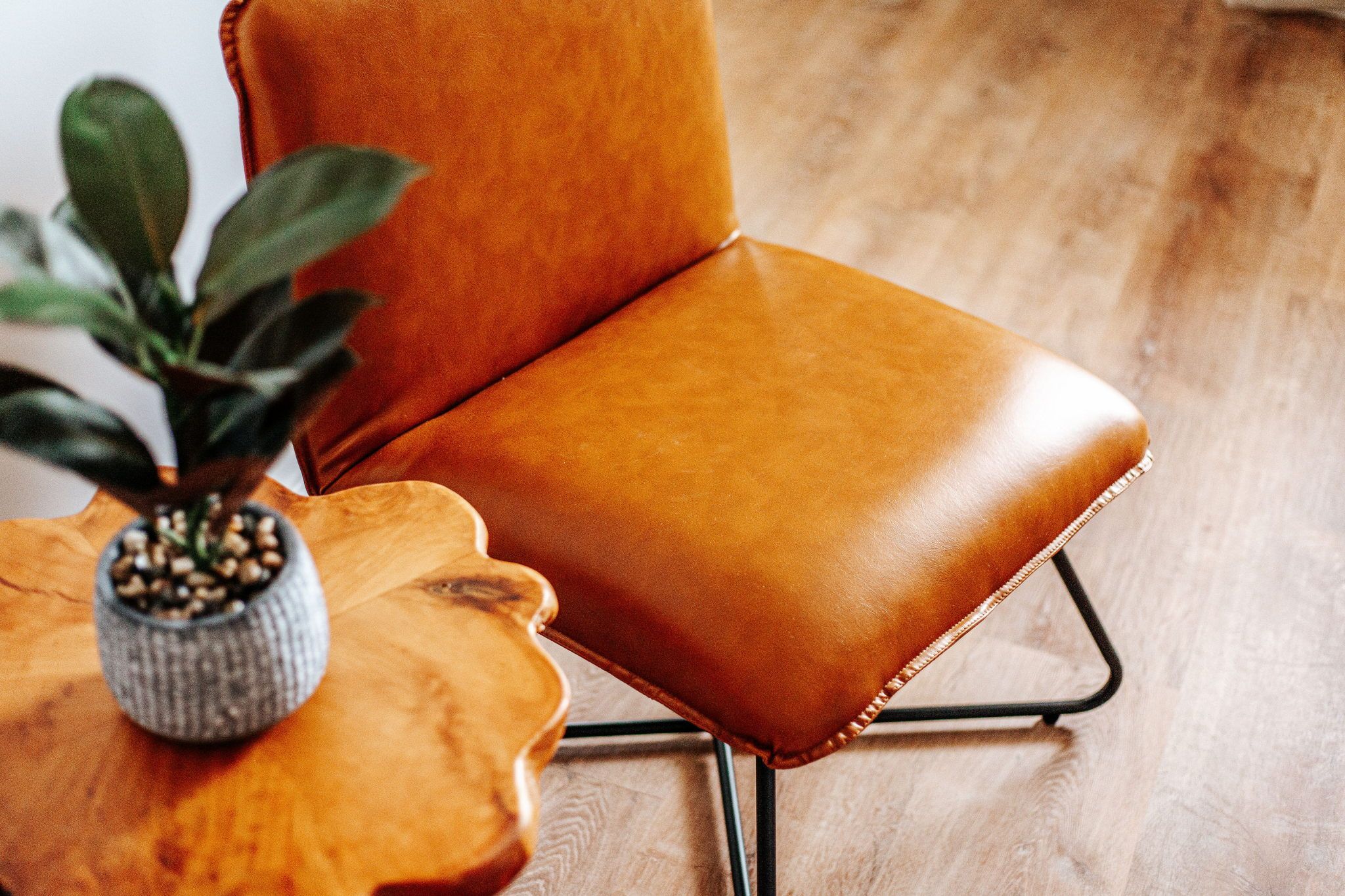 image Relax in style with a plush leather chair and a stunning wooden side table, perfect for unwinding.