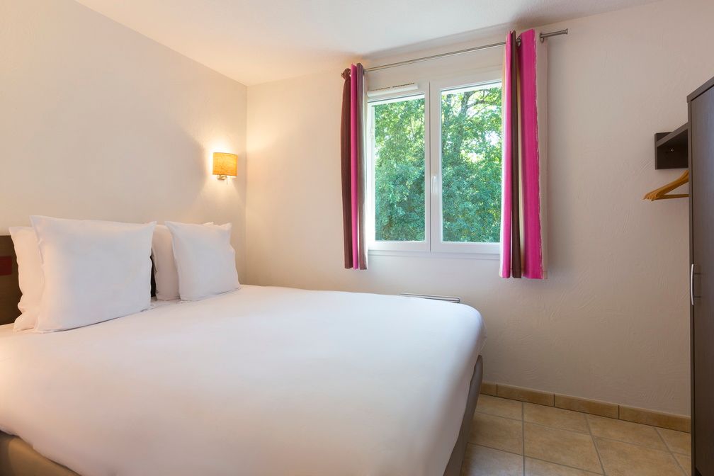 image A calm and simply furnished bedroom designed for good rest — after a day of tennis, volleyball, and swimming, that's exactly what's needed.