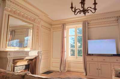 The living space from another angle, showing the ornate fireplace and floral sofas at the heart of this private-hire estate.