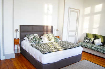 A bedroom combining a king bed and a sofa, providing flexible sleeping arrangements within this exclusively rented estate.
