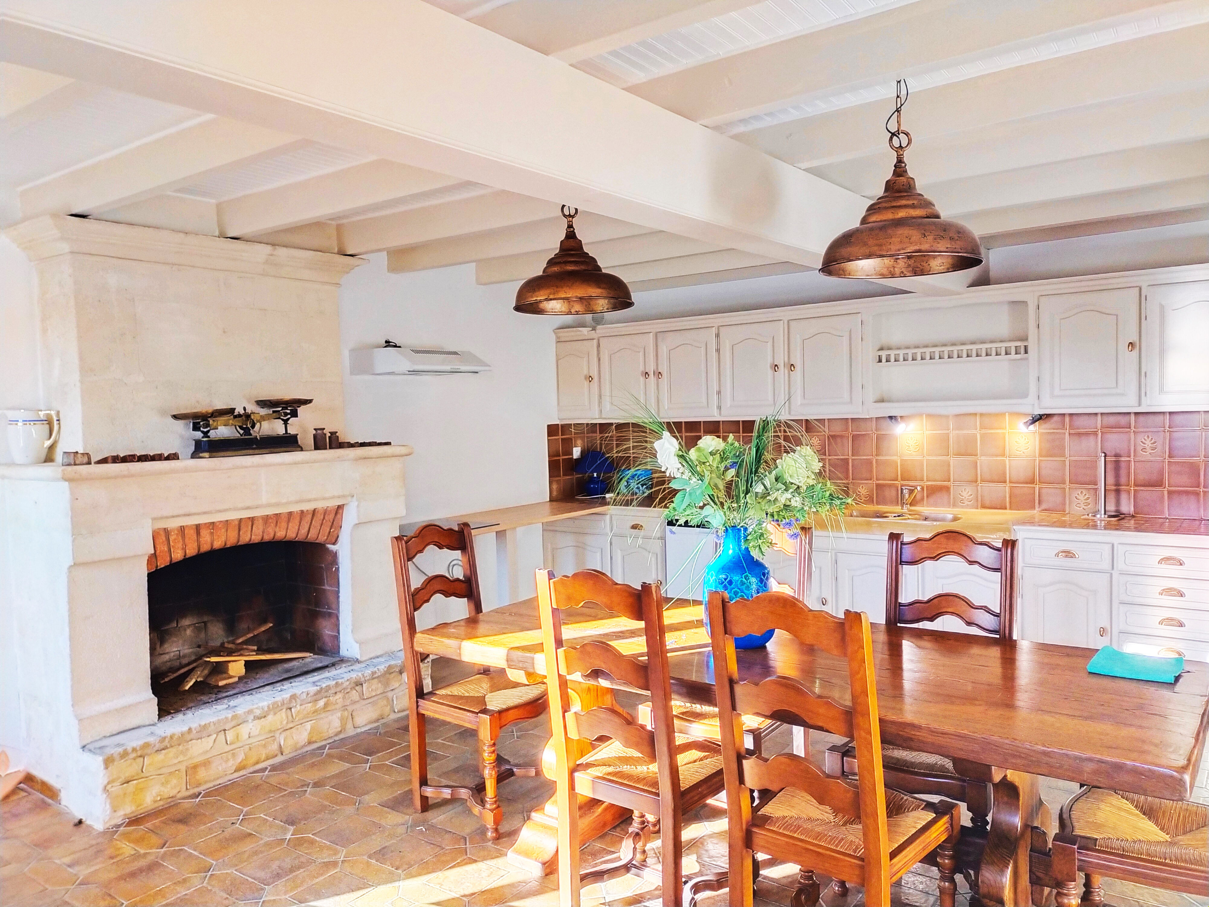image The fully equipped kitchen features exposed beams, copper pendant lights, and a large dining table where the whole group can gather.