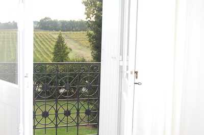 A window looking out over the estate's organic vineyards, a view that defines every stay at this Côtes de Bourg retreat.