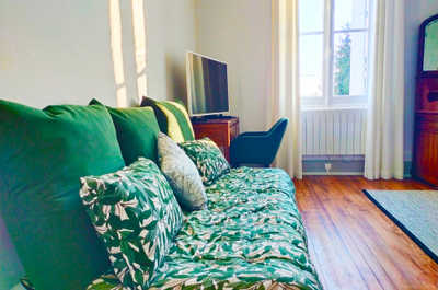 The sofa bed opens to the enclosed garden, with vineyard greenery visible through the window just beyond.