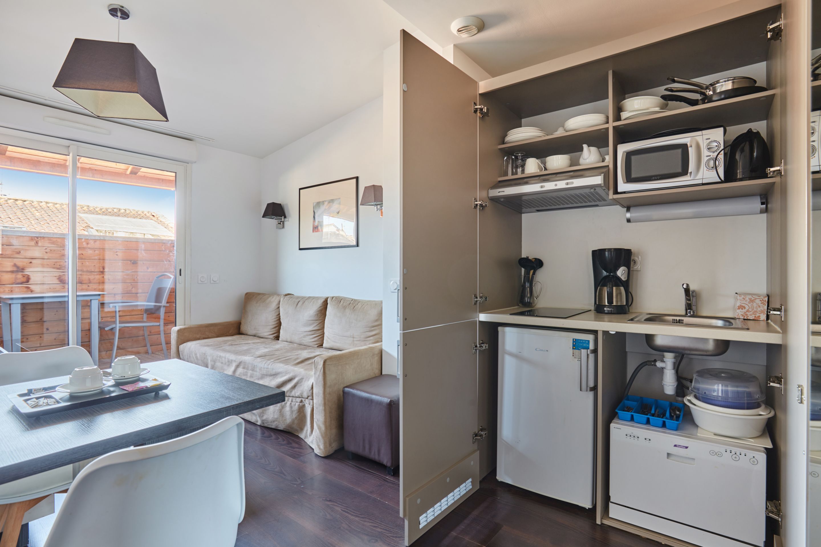 image The fully equipped kitchenette includes a ceramic hob, dishwasher, microwave, and kettle, everything you need for a self-sufficient stay.