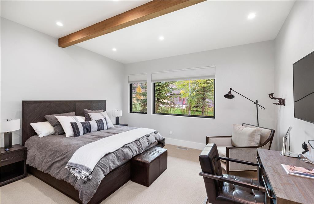 image King bedroom with large windows framing the Snake River Valley and en-suite bath with radiant heated floors