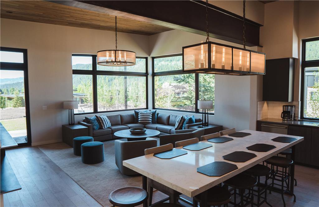 image Open living area with a sectional sofa, stone-topped kitchen island, and wood-beam ceiling