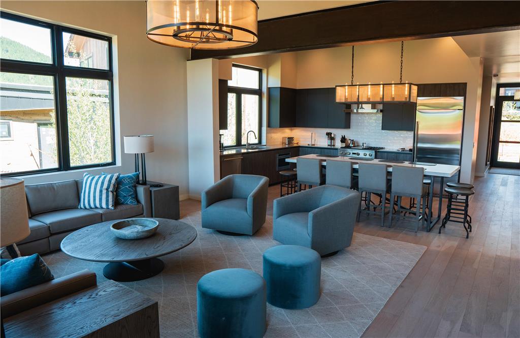 image Living area with chairs around a round table, dark cabinetry, and views of greenery through the windows