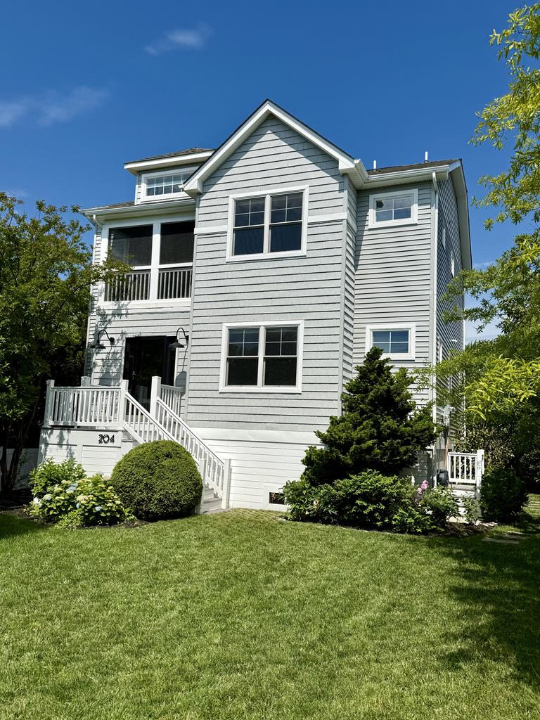 image Admire the charming exterior surrounded by lush greenery, where beach days start just steps away from your door.