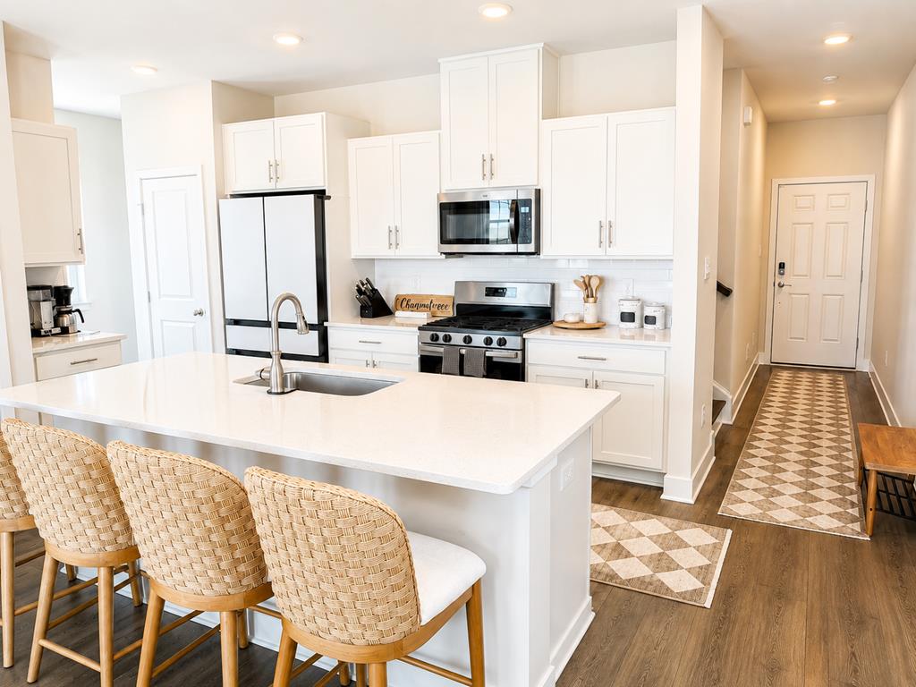 image Gather around the sleek island in this modern kitchen, perfect for meal prep and morning coffee.